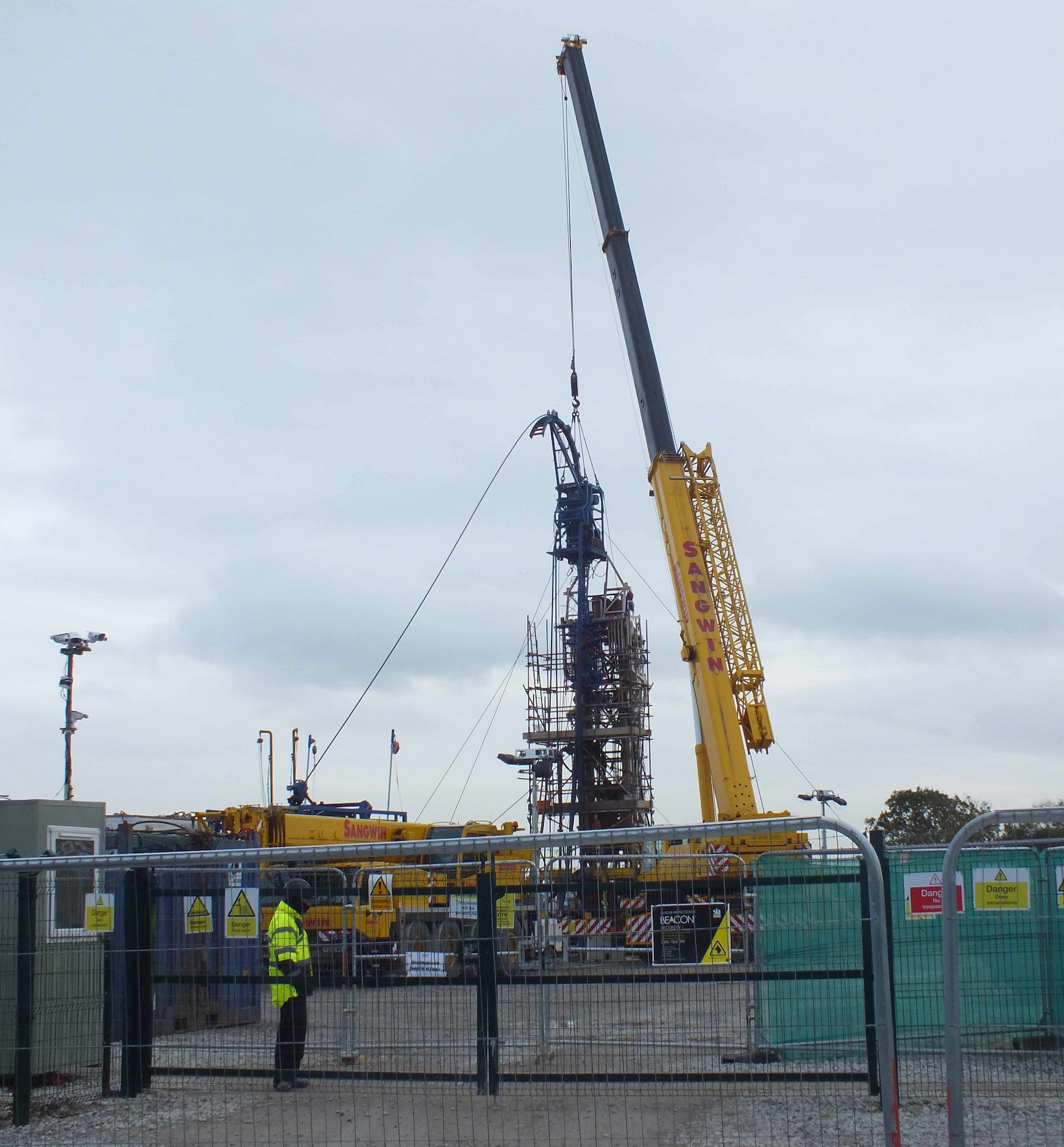 Well intervention equipment (blue) in use; scaffolding tower; work-over rig (white) behind.
